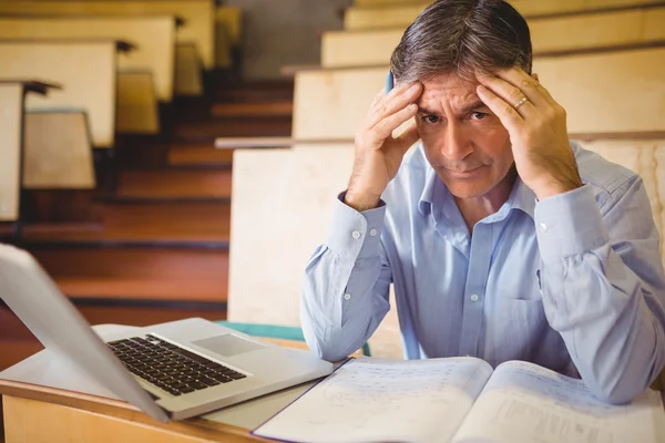 Professor deprimido sentado com notas e laptop — Fotografia de Stock