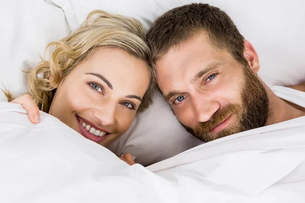 Retrato de pareja sonriendo en la cama — Foto de Stock