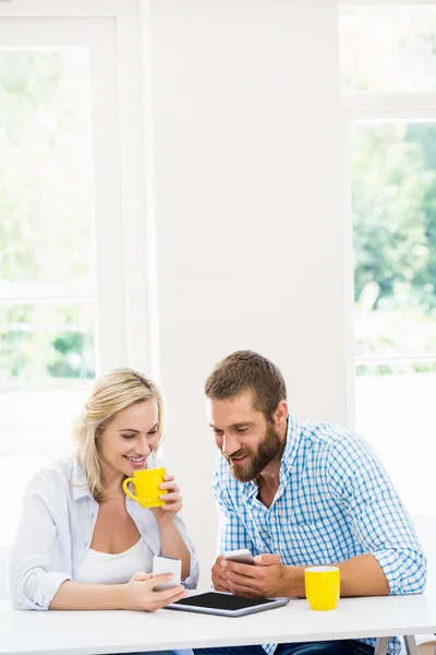 Пара використовує мобільний телефон, маючи каву — стокове фото