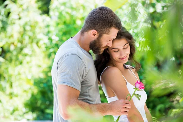 Mann bietet Frau eine Rose an — Stockfoto