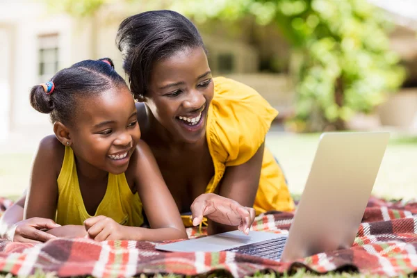 Kijken naar een laptop en gelukkige familie — Stockfoto