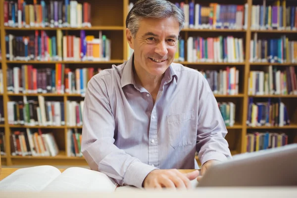 Retrato del profesor feliz sentado en el escritorio usando el ordenador portátil —  Fotos de Stock