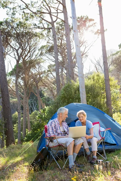 Senior couple relaxing beside their tent — Stock Photo, Image