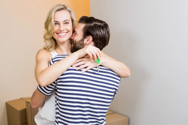 Jovem casal abraçando na sala de estar — Fotografia de Stock