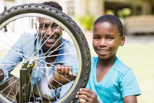 Ευτυχισμένη οικογένεια επισκευή ένα ποδήλατο — Φωτογραφία Αρχείου