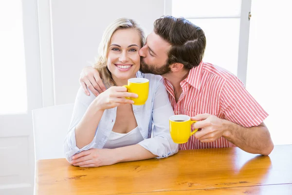 Man kussen vrouw terwijl het hebben van koffie — Stockfoto