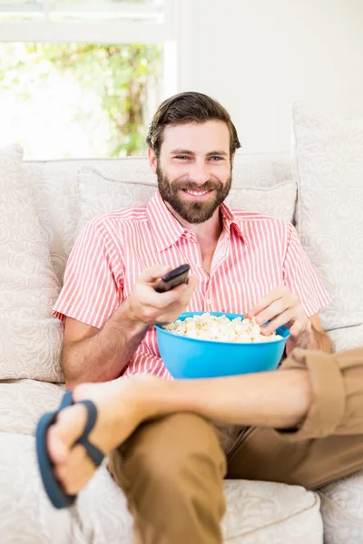 Man sitter på soffan tittar på TV — Stockfoto