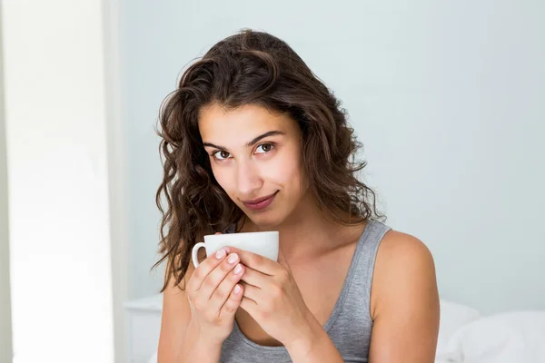 Close up of woman having coffee on bed — Stock Photo, Image