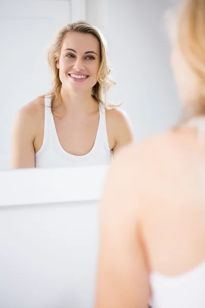 Mladá žena při pohledu do zrcadla — Stock fotografie