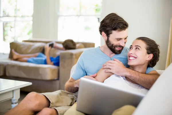 Feliz jovem casal abraçando no sofá — Fotografia de Stock