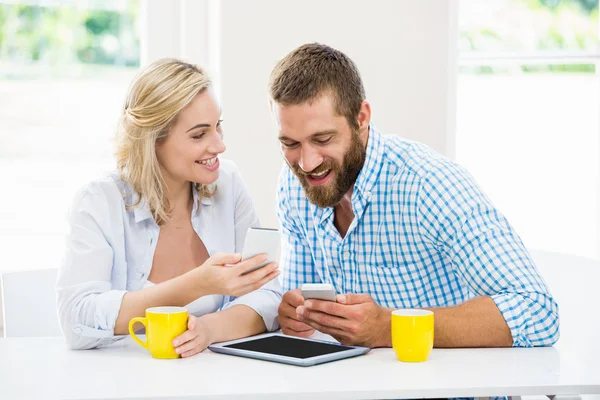 Casal sorridente usando um telefone celular — Fotografia de Stock