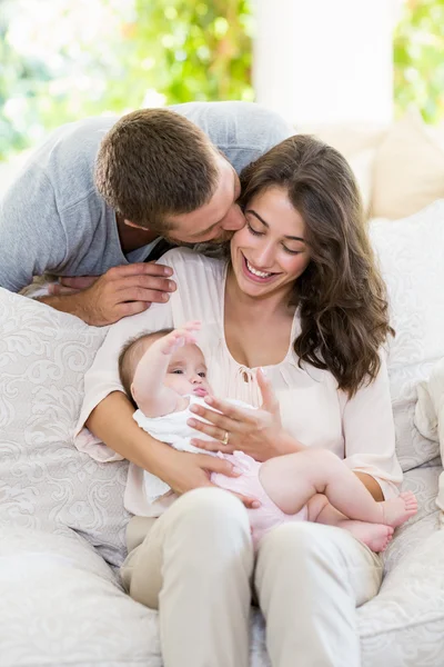 Donna baciare bambino mentre l'uomo la bacia da dietro — Foto Stock