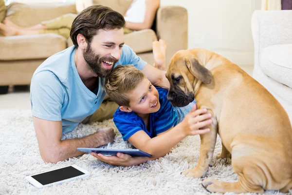 Far och son leker med en hund — Stockfoto