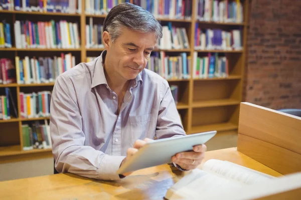 Profesor sentado en el escritorio usando tableta digital — Foto de Stock