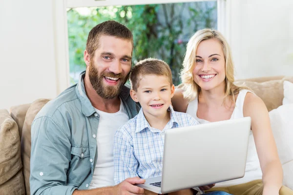 Los padres y el hijo usando ordenador portátil en la sala de estar —  Fotos de Stock