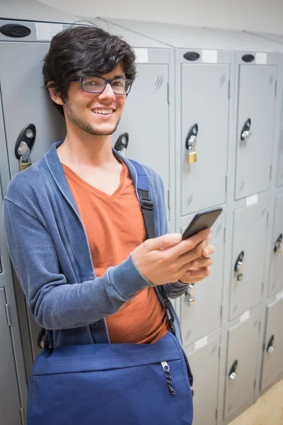Portret van lachende student gebruik mobiele telefoon in kleedkamer — Stockfoto