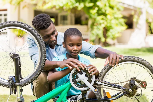 Felice famiglia che ripara una bici — Foto Stock