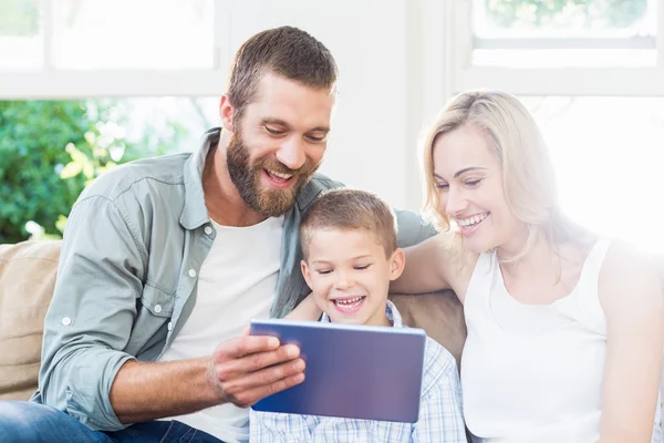 Familie met behulp van digitale tablet in woonkamer — Stockfoto