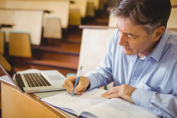 Professor schrijven in boek bij Bureau — Stockfoto