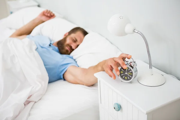 Hombre dormido despertado por una alarma en la cama —  Fotos de Stock