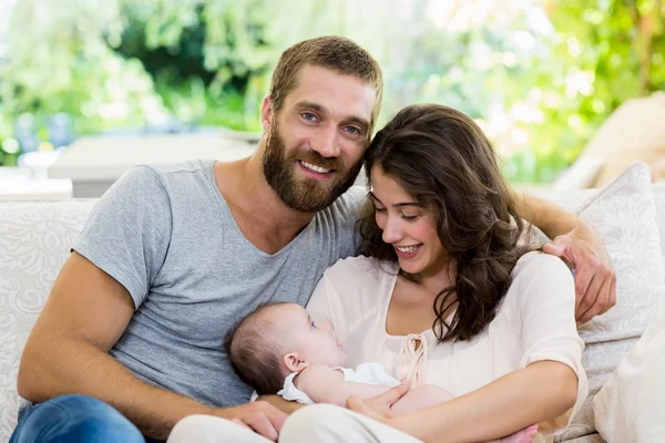 Glückliche Eltern mit ihrem Baby im Wohnzimmer — Stockfoto