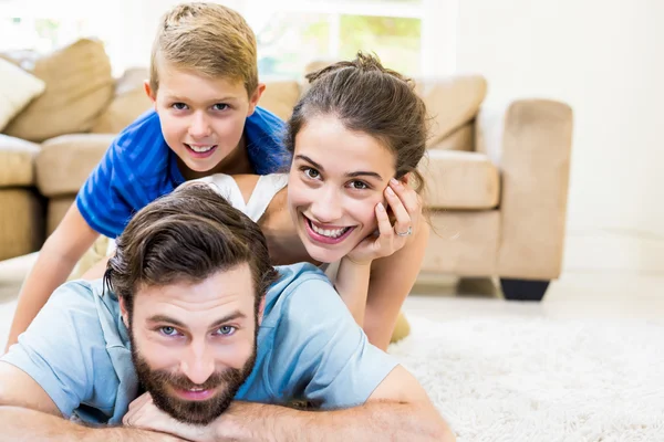 Ritratto di genitori e figlio sdraiato sul tappeto — Foto Stock