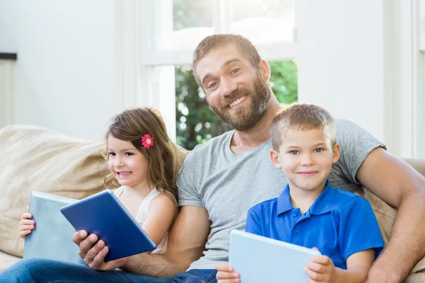 Otec sedí s jeho dětmi na pohovce — Stock fotografie