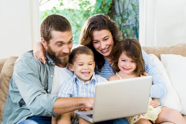 Família sorridente com laptop — Fotografia de Stock