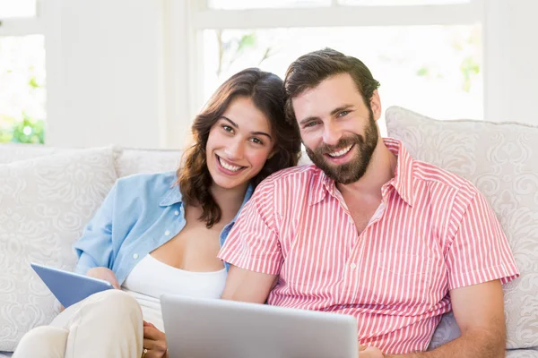 Retrato de casal usando tablet digital e laptop — Fotografia de Stock