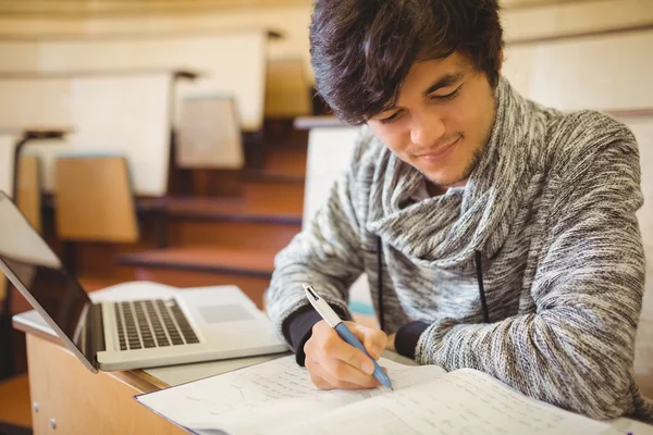 若い学生がノートに書いて机に座って — ストック写真