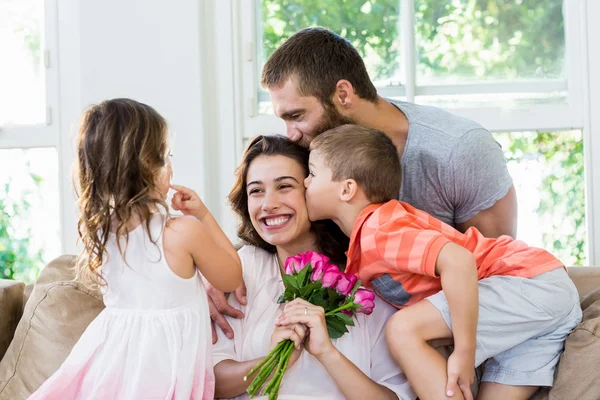 Moeder ontvangende bos bloemen van haar familie — Stockfoto