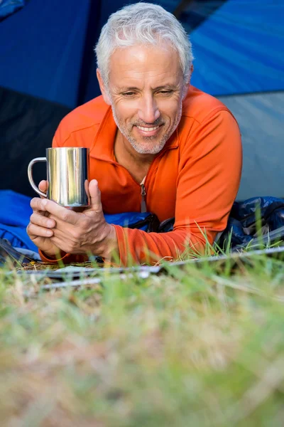 Mature man smiling and holding a mug — Stock Photo, Image