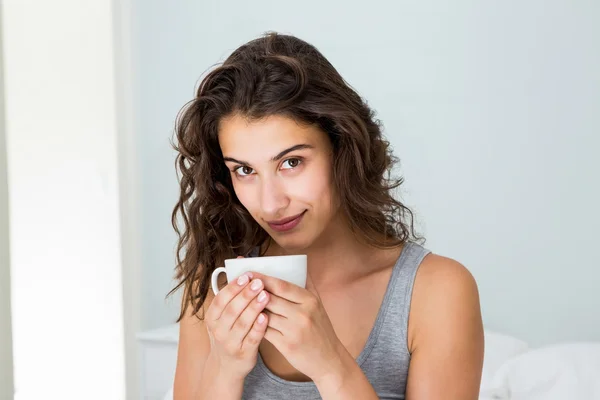 Close up van vrouw met koffie op bed — Stockfoto