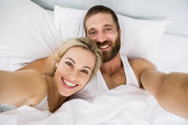 Porträt eines Paares, das im Bett lächelt — Stockfoto