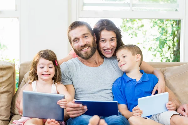 Padres con sus hijos usando computadora portátil y tableta digital —  Fotos de Stock