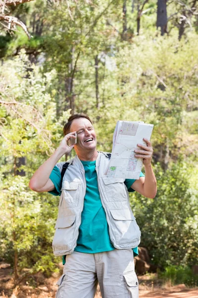 Homem sênior está lendo e falando ao telefone — Fotografia de Stock