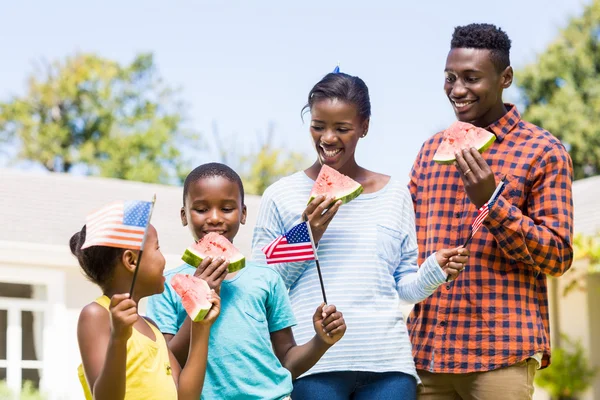 Familia feliz comiendo sandía y mostrando bandera de EE.UU. — Foto de Stock