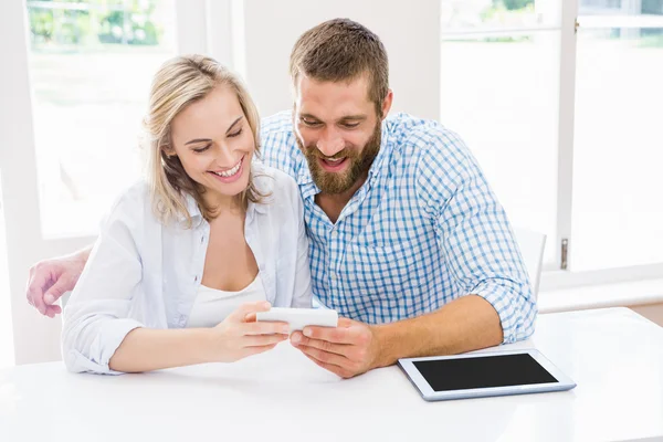 Smiling couple using a mobile phone — Stock Photo, Image