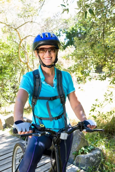 Senior woman is smiling with her bike — Stock Photo, Image