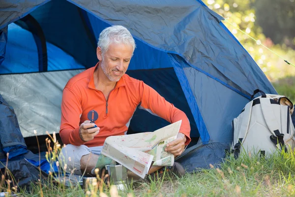 Volwassen man op zoek naar een kaart en een kompas te houden — Stockfoto
