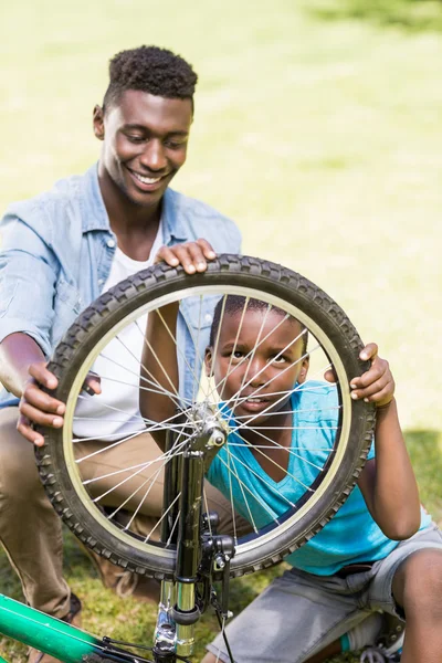 Felice famiglia che ripara una bici — Foto Stock