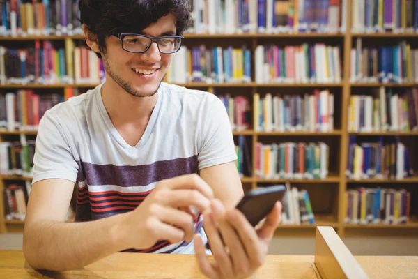 Feliz joven estudiante usando el teléfono móvil — Foto de Stock