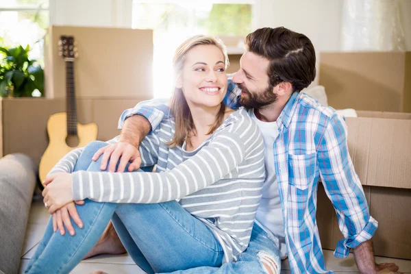 Pareja sonriente sentada en el suelo — Foto de Stock