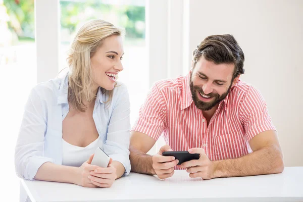 Χαμογελώντας ζευγάρι χρησιμοποιώντας ένα κινητό τηλέφωνο — Φωτογραφία Αρχείου
