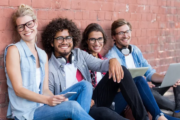 Porträt von Freunden, die gegen die Wand sitzen — Stockfoto