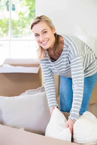 Portrait of young woman unpacking carton boxes — Stock Photo, Image