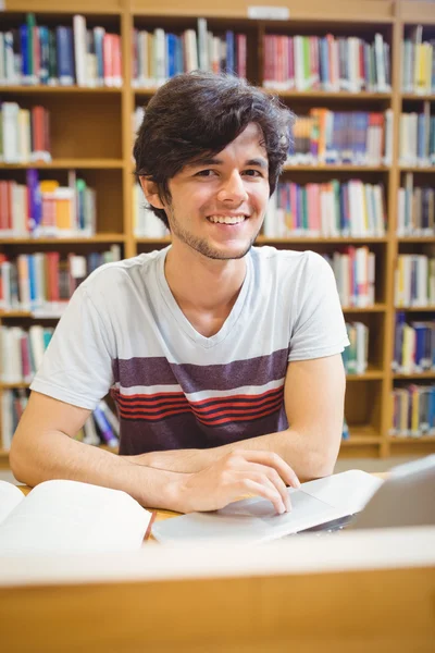 Retrato de un joven estudiante feliz usando su computadora portátil — Foto de Stock