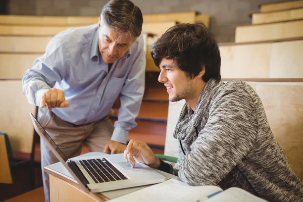 Profesor ayudando a un estudiante en el aula — Foto de Stock