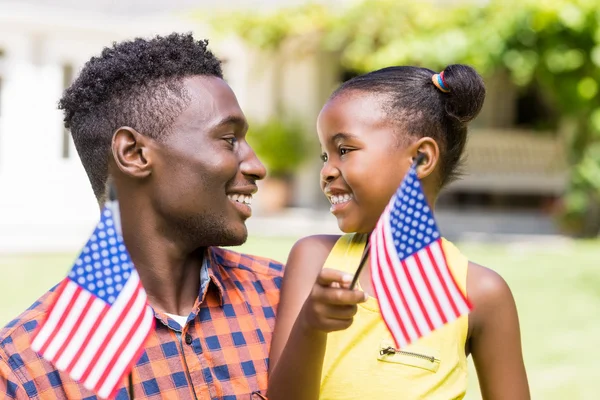 Familia feliz mostrando bandera de EE.UU. — Foto de Stock