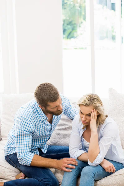 Man troost haar vrouw in woonkamer — Stockfoto